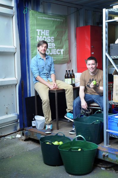 THE MOSS CIDER PROJECT, MANCHESTER. FOUNDER DAN HASLER, 32, AND DIRECTOR JOE WEEKS, 40 , AT THE OLD SHIPPING CONTAINER IN MOSS SIDE WHERE THEY PRESS THE APPLES. PHOTO BY CLARE KENDALL.